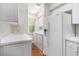 Bright laundry room with white washer/dryer, cabinets, countertop and wooden floors at 157 Egret Run Ln. # 523, Pawleys Island, SC 29585