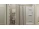 Bright bathroom with modern white fixtures and a shower featuring a striped curtain at 1704 Hunting Harris Ct # 1, Ocean Isle Beach, NC 28469