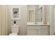 Modern bathroom with a white vanity, toilet, and stylish wall art at 1704 Hunting Harris Ct # 1, Ocean Isle Beach, NC 28469