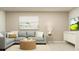 This living room is well-appointed with beach themed art, a modern lamp, sectional seating, and bright natural light at 1708 Hunting Harris Ct # 2, Ocean Isle Beach, NC 28469