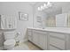 Well-lit bathroom with a white vanity, large mirror, and toilet at 172 Ella Kinley Circle # 101, Myrtle Beach, SC 29588