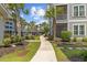 Beautifully landscaped walkway leading to condo building with a pool view at 172 Ella Kinley Circle # 101, Myrtle Beach, SC 29588