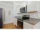 Well-equipped kitchen featuring stainless steel appliances, granite countertops and white cabinets at 172 Ella Kinley Circle # 101, Myrtle Beach, SC 29588