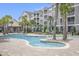 A well-maintained pool area with sun loungers, umbrellas, and lush landscaping at 172 Ella Kinley Circle # 101, Myrtle Beach, SC 29588