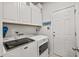 Bright laundry room features modern Maytag washer and dryer, white cabinets, and convenient access door at 1833 Lake Egret Dr., North Myrtle Beach, SC 29582