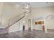 Spacious living room featuring soaring ceilings, staircase, wood floors and seamless flow to the kitchen at 185 Fulbourn Pl., Myrtle Beach, SC 29579