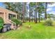 Green backyard with grass, trees, and small bird bath feature at 1880 Plantation Dr., Myrtle Beach, SC 29577