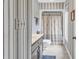 Bright bathroom featuring striped wallpaper, dark vanity, patterned shower curtain and tile floor at 1880 Plantation Dr., Myrtle Beach, SC 29577