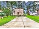 Two-story home with a well-manicured lawn, long driveway, and mature landscaping at 1880 Plantation Dr., Myrtle Beach, SC 29577