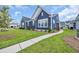 Charming blue two-story home with white trim, manicured lawn, and paved walkway on a sunny day at 2080 Silver Island Way, Murrells Inlet, SC 29576