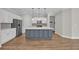 Modern kitchen featuring stainless steel appliances, a large island, white cabinets, and hardwood floors at 2080 Silver Island Way, Murrells Inlet, SC 29576