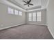 Main bedroom showcasing tray ceiling, ceiling fan, neutral walls, and large windows at 2080 Silver Island Way, Murrells Inlet, SC 29576