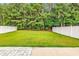 View of the expansive, well-maintained backyard with a lush lawn, framed by a white fence and mature trees at 218 Calhoun Falls Dr., Myrtle Beach, SC 29579