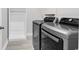 Laundry room featuring modern washer and dryer units with a built-in storage cabinet at 218 Calhoun Falls Dr., Myrtle Beach, SC 29579
