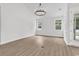 Bright, airy living room with wood-look floors and modern chandelier and natural light from the windows at 218 Calhoun Falls Dr., Myrtle Beach, SC 29579