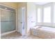 Bathroom featuring a glass door shower, soaking tub and bright windows at 2191 Jasmine Rd., Loris, SC 29569