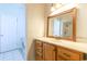 Bathroom featuring a wooden vanity, framed mirror, and a view of the shower through the door at 2191 Jasmine Rd., Loris, SC 29569