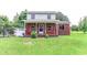 A inviting brick and siding two-story home featuring a cozy front porch and mature landscaping at 2191 Jasmine Rd., Loris, SC 29569