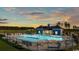 Community pool and clubhouse at sunset surrounded by trees at 2220 Flatleaf Ct, Longs, SC 29568