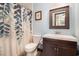 Bathroom features a dark wood vanity with a matching framed mirror and a shower with a patterned curtain at 2257 Huntingdon Dr. # H, Myrtle Beach, SC 29575
