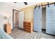 Cozy bedroom with wood accent wall, wooden dresser, sliding barn door to closet, and wood-look flooring at 2257 Huntingdon Dr. # H, Myrtle Beach, SC 29575