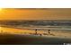 Tranquil beach scene with seagulls standing on the wet sand, ocean and a vibrant sunset at 226 Ladyfish Loop, Sunset Beach, NC 28468