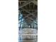 Low-angle view under a pier, showing wooden support beams and the ocean waves at 226 Ladyfish Loop, Sunset Beach, NC 28468