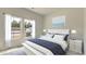 Bright bedroom features a large bed with stylish white and blue bedding, plus natural light from the double windows at 234 Ladyfish Loop, Sunset Beach, NC 28468