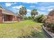Brick house with a concrete patio, palm trees, and a well-manicured lawn at 2384 Covington Dr., Myrtle Beach, SC 29579