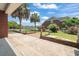 The brick-laid backyard features a white picket fence, manicured shrubbery, and tall palm trees at 2384 Covington Dr., Myrtle Beach, SC 29579