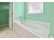 This bright bathroom features a soaking tub, neutral tile floors, and a spacious design at 2384 Covington Dr., Myrtle Beach, SC 29579