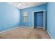 A quaint bedroom features blue walls, neutral carpet, a window, and a closet at 2384 Covington Dr., Myrtle Beach, SC 29579