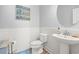 Cozy powder room with pedestal sink, toilet, wainscoting, and beach-themed wall decor at 277 Splendor Circle, Murrells Inlet, SC 29576