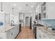 Modern kitchen featuring white cabinets, granite countertops, stainless steel appliances, and light blue backsplash at 277 Splendor Circle, Murrells Inlet, SC 29576