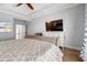 Bedroom featuring a ceiling fan, hardwood floors, tray ceiling, television, and large window at 277 Splendor Circle, Murrells Inlet, SC 29576