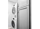 Modern laundry room with stacked washer and dryer and gray cabinets at 315 73Rd Ave. N # 2, Myrtle Beach, SC 29572
