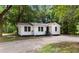 Charming white cottage-style home with a metal roof, gravel driveway, and mature trees at 3519 Cates Bay Hwy., Conway, SC 29527