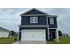 Charming two-story home with a white garage door, blue siding, and a well-manicured lawn at 3579 Ashridge Way, Conway, SC 29526