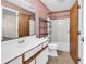 A bathroom featuring a white vanity, a shower-tub combo, and pink textured wallpaper at 3700 Golf Colony Lane # 25G, Little River, SC 29566