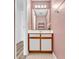 A bathroom with white vanity, a large mirror, and pink patterned wallpaper at 3700 Golf Colony Lane # 25G, Little River, SC 29566