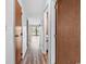 Bright hallway with wood-look flooring leading to a sliding glass door and balcony at 3700 Golf Colony Lane # 25G, Little River, SC 29566