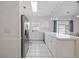 Bright kitchen features white cabinets, tiled floors, stainless steel refrigerator, and a sunlit breakfast nook at 3983 Forsythia Ct. # 301, Myrtle Beach, SC 29588