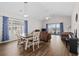 Open-concept living and dining area with hardwood floors, vaulted ceilings, sliding glass doors to the porch, and comfortable seating at 3983 Forsythia Ct. # 301, Myrtle Beach, SC 29588
