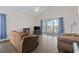 Cozy living room featuring hardwood floors, vaulted ceiling, access to a screened-in porch, and comfortable seating at 3983 Forsythia Ct. # 301, Myrtle Beach, SC 29588