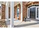 Inviting covered front porch with white columns, brick facade, and a stylish black front door at 4232 Pointer Ct., Myrtle Beach, SC 29579
