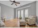 Cozy living room featuring hardwood floors, a ceiling fan, and large windows with sheer curtains at 4232 Pointer Ct., Myrtle Beach, SC 29579