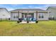 This backyard features a screened-in porch, grill, and outdoor seating, perfect for relaxing and entertaining at 446 Rycola Circle, Surfside Beach, SC 29575