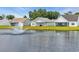 Back exteriors with lush lawns meet a serene lake and water feature, complemented by well-maintained landscaping at 446 Rycola Circle, Surfside Beach, SC 29575