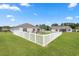 Expansive backyard enclosed by a white picket fence, featuring a well-manicured lawn and an inviting patio space at 568 Mossbank Loop, Longs, SC 29568