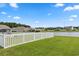 Green backyard with a white picket fence and view of the lake at 568 Mossbank Loop, Longs, SC 29568
